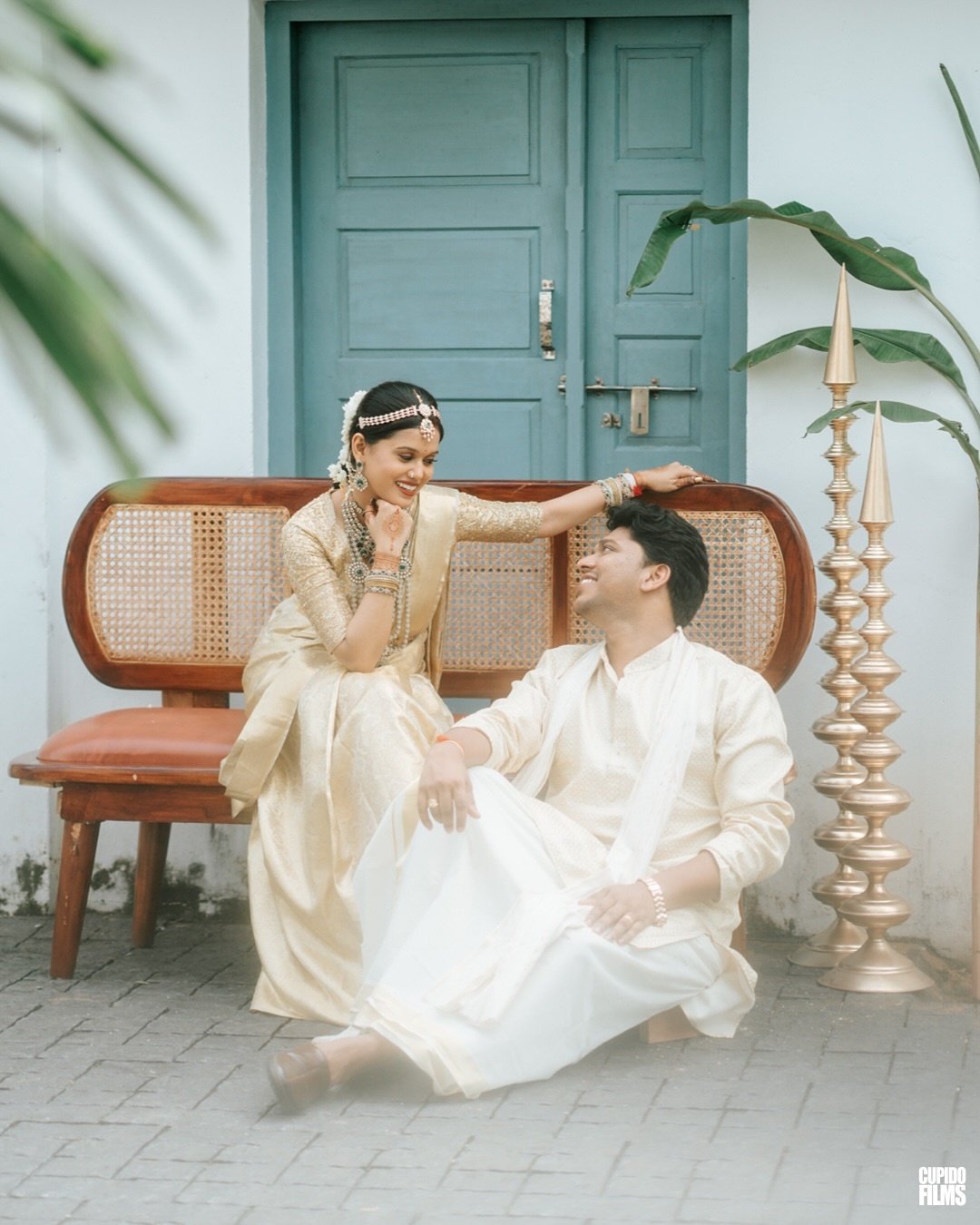 A wedding couple sharing a playful seated portrait