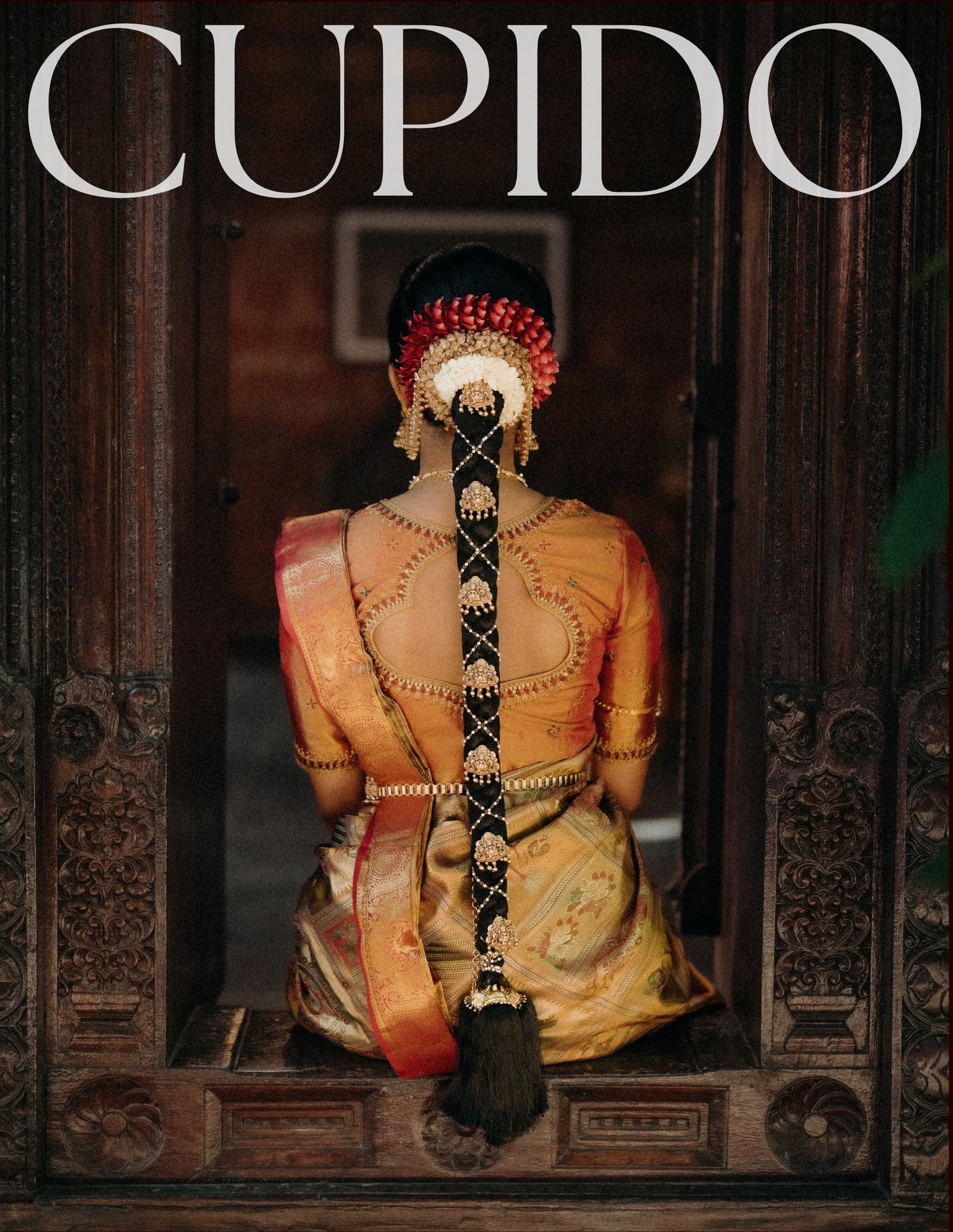 A bride in traditional wedding attire framed by carved wooden doors